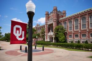 South entrance of Bizzell with OU flag on a lamp post in the forefront