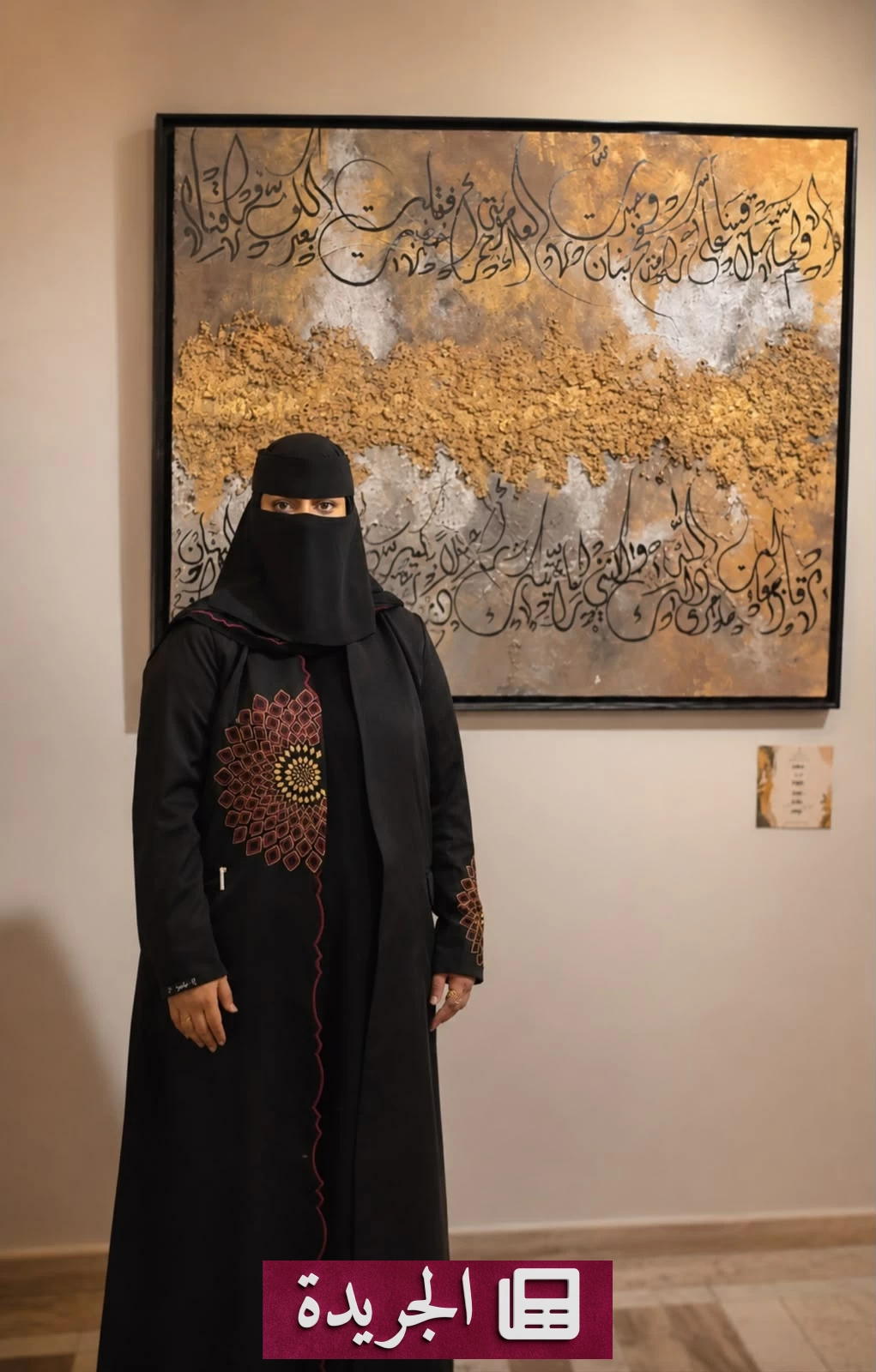 الفنانة التشكيلية منى محمد حجر أثناء عملها الفني الذي يجمع بين الحرف العربي والتشكيل والشعر